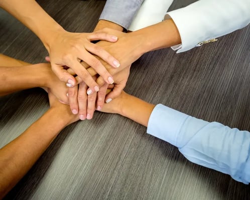 Business team in a meeting with their hands together.jpeg